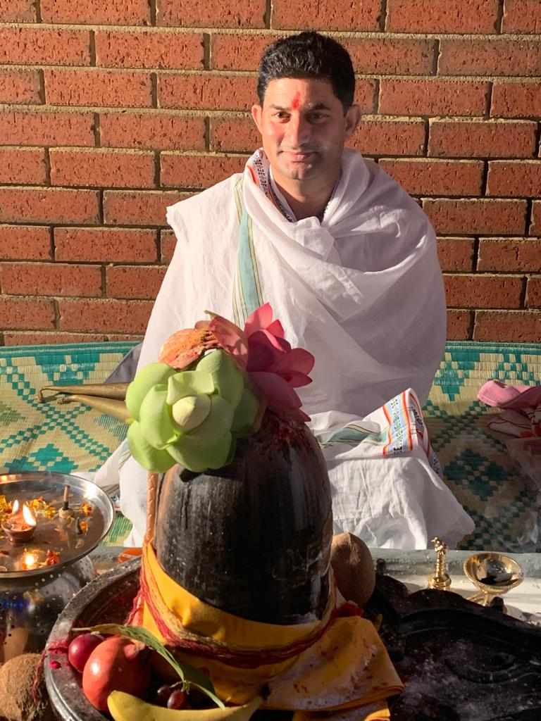 Pandit Rajesh Tiwari performing Rudrabhishek with decorated Shivling, lotus flowers and ritual offerings